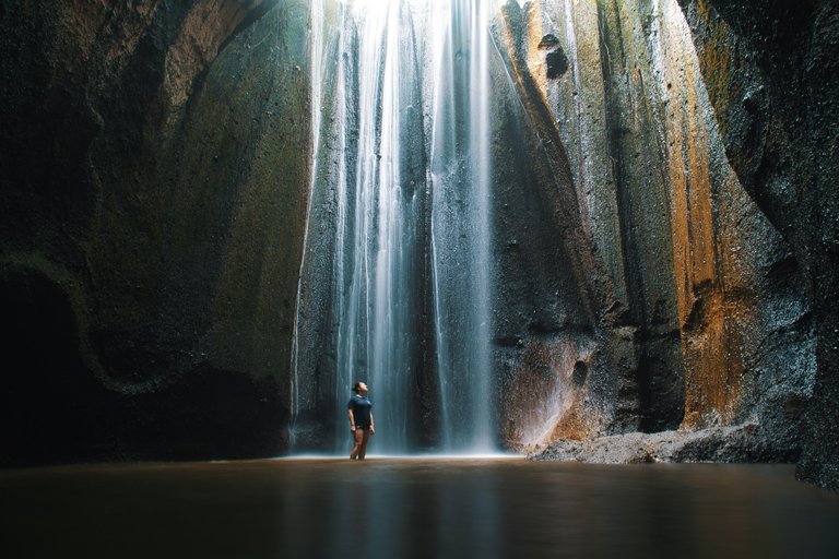 Persona dentro de la cascada Tukad Cempung, Bali