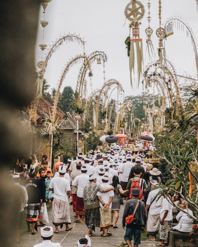 Varias personas paseando por las calle decoradas con Penjar durante las festividades Galungan y Kuningan