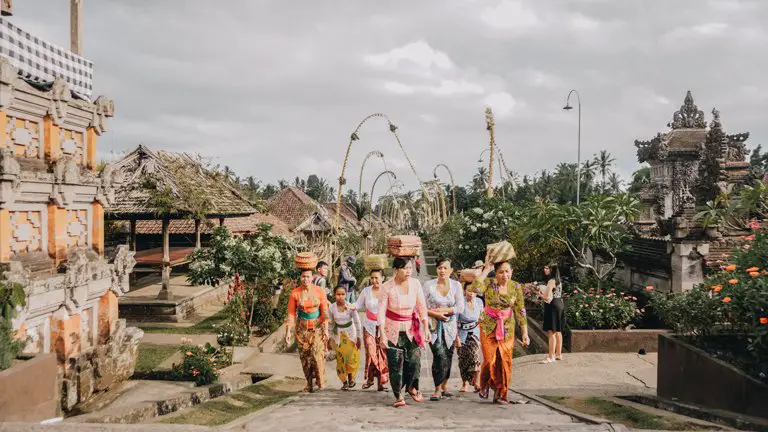 Varias personas llevando ofrendas en la cabeza en el pueblo tradicional Penglipuran, Bali