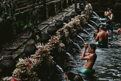 Muchas personas purificandose en Melasti en Tirta Empul, Bali